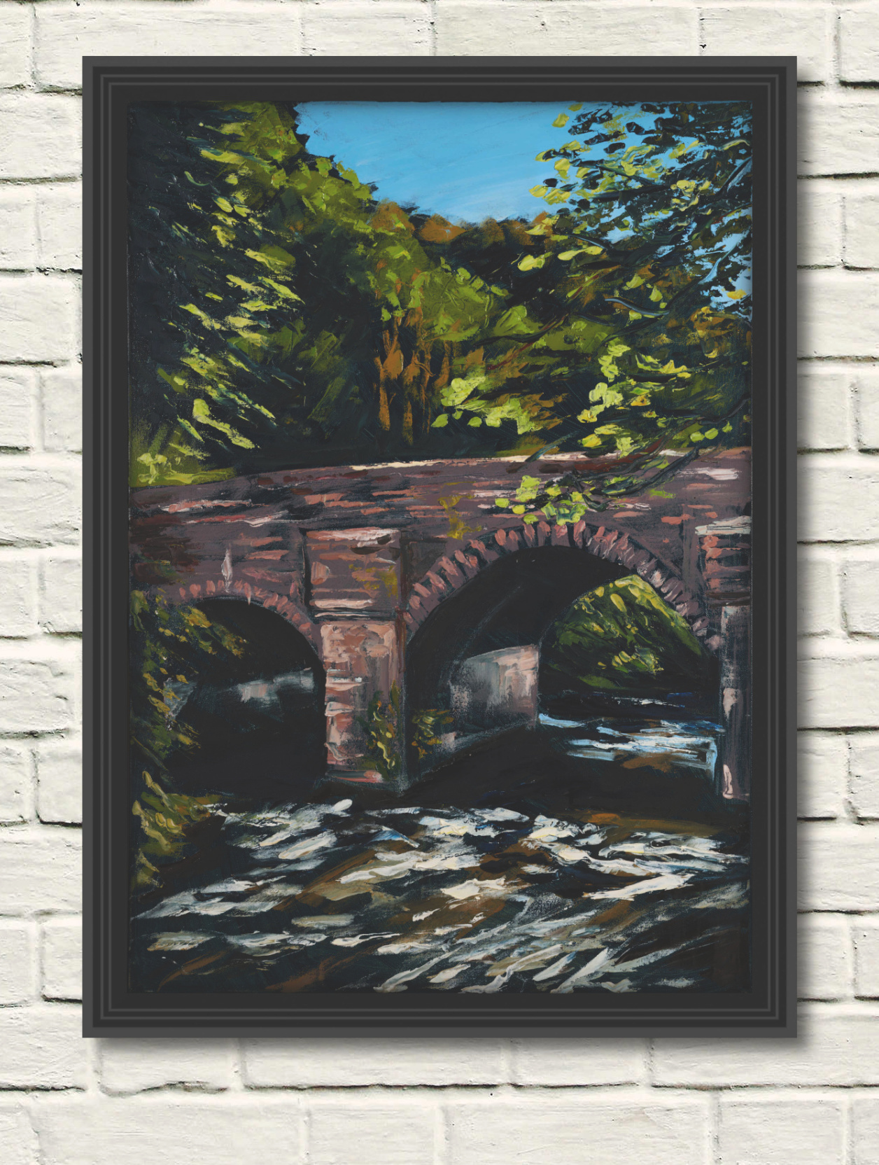 artist rod coyne's oil painting of the bridge over the meeting of the waters. here in a black frame on a white wall