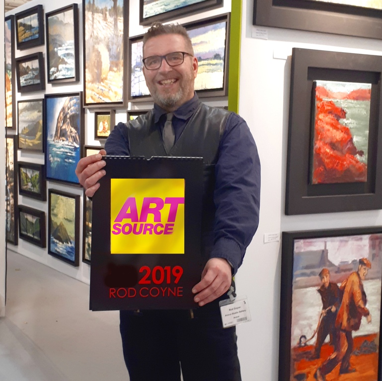 2018 Rod holds Art Source_crop 23 square_websize Rod Coyne photographed holding a sign for RDS in Art Source 2019