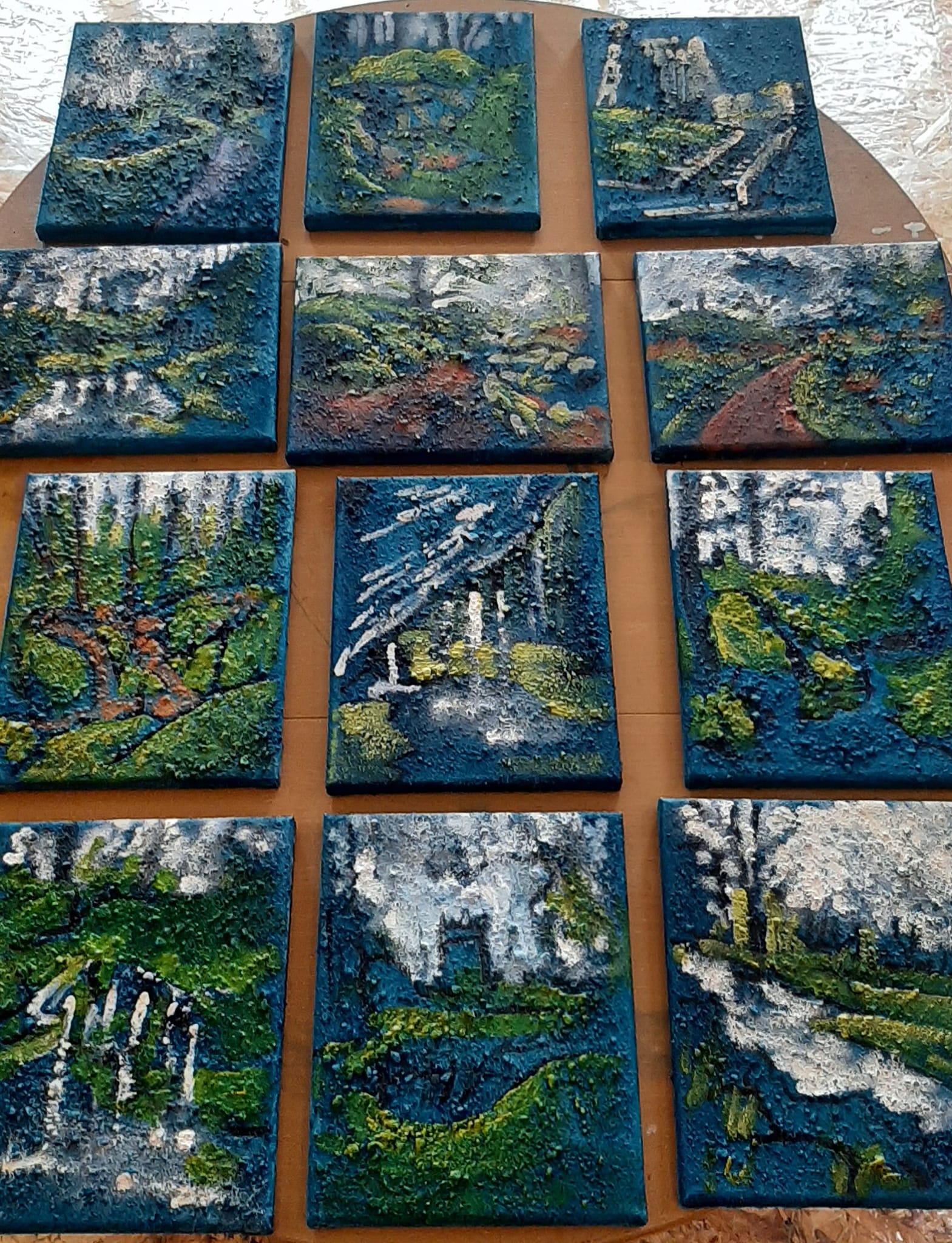 Developing color scheme, 12 canvases laid out on a table. Blarney Castle & Gardens collection is artist Rod Coyne's new work in progress.